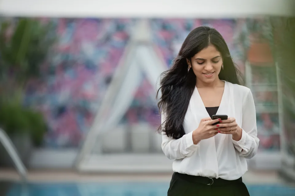 Une femme debout consulte son téléphone : repérer cinq personnes dont le travail t'intéresse vraiment